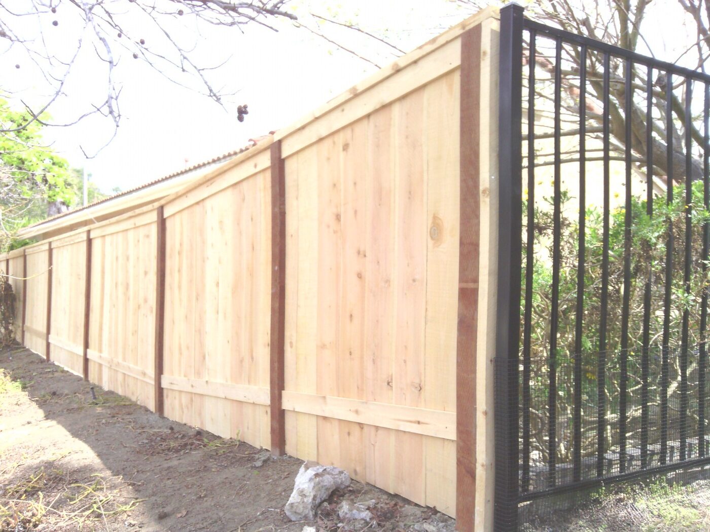 Ornamental iron fence mounted above a block retaining wall