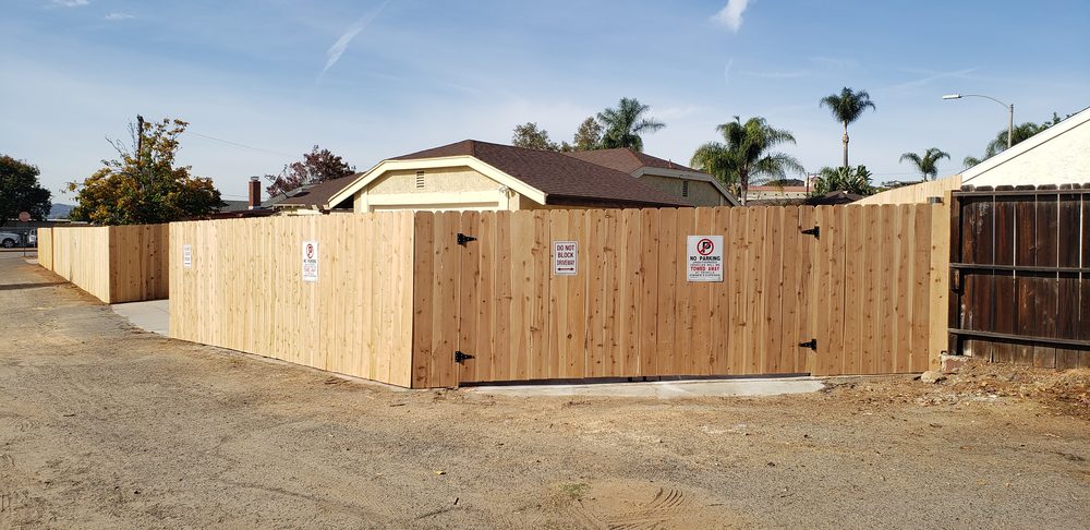 Wide wood double drive gate across a driveway