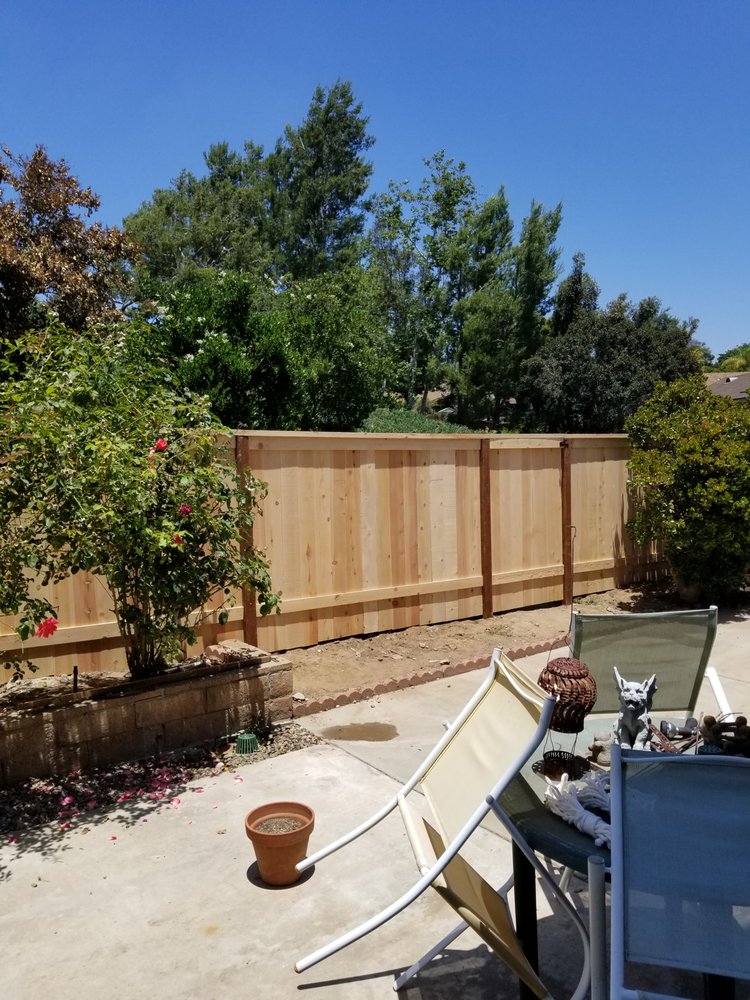 Replacement wood fence rebuilt behind a back patio
