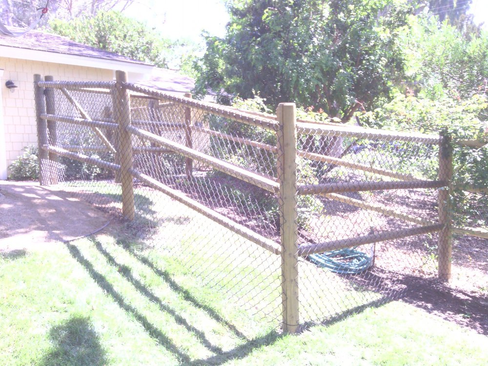 Ranch rail fence backed with wire mesh to hold smaller animals