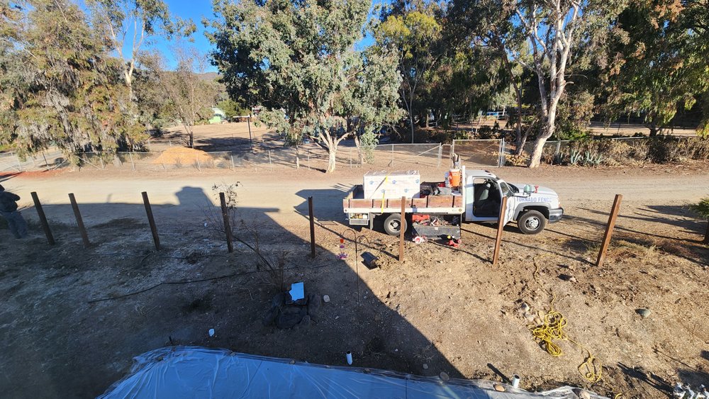 New pressure-treated posts set in concrete after the old fence was removed