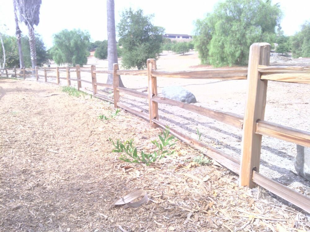 Split rail style ranch fence running along a rural North County property line